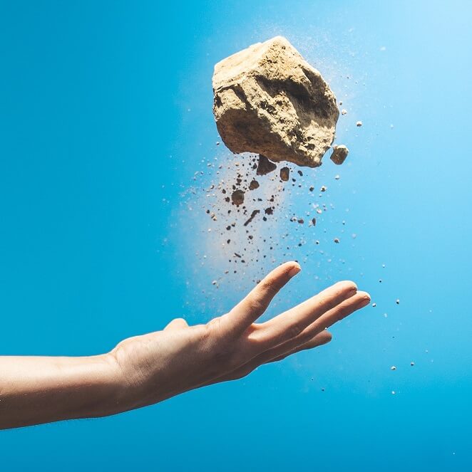 Ręka podrzuca kamień